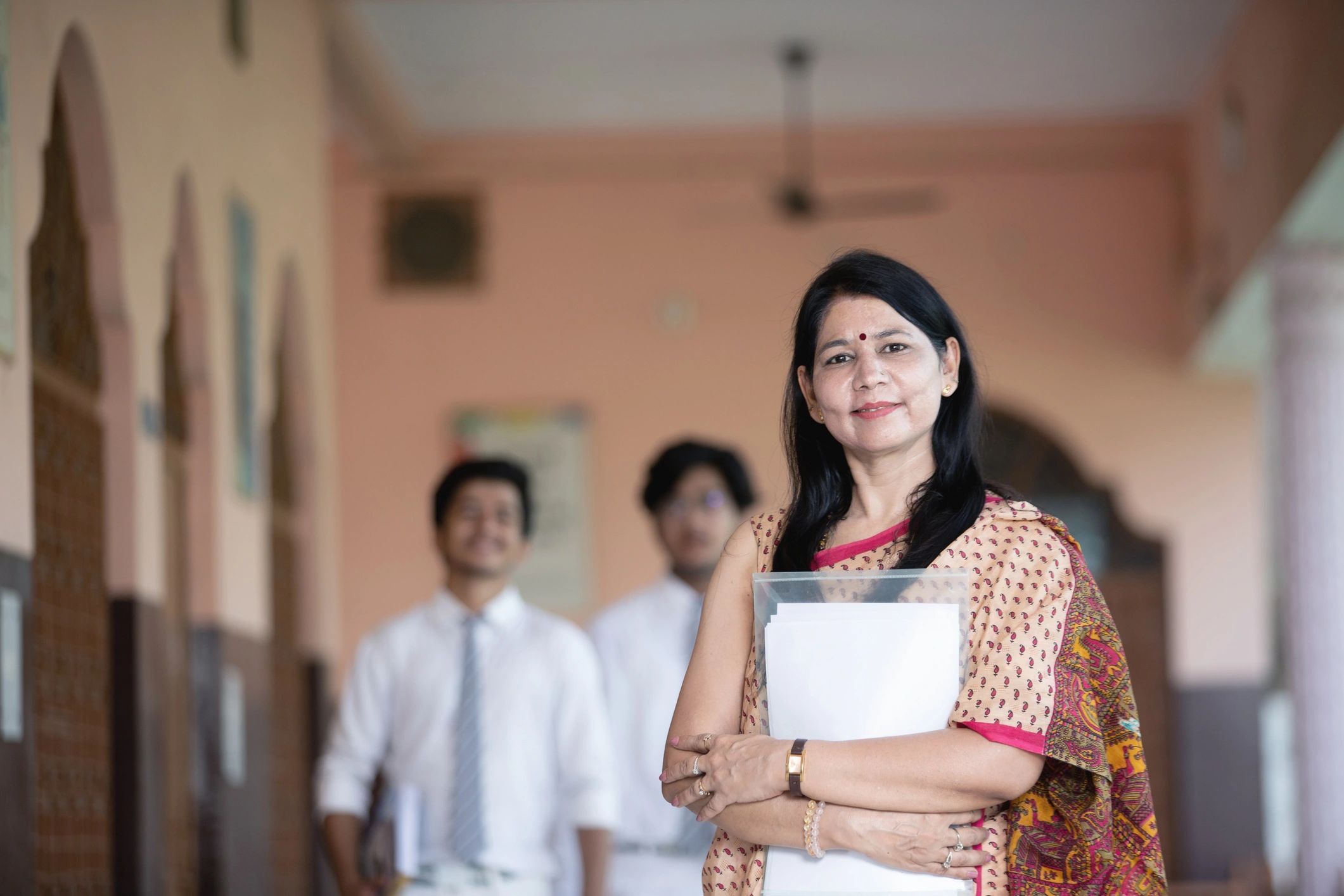 Community member standing outdoors with people in the background